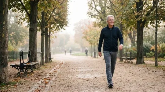 Personne senior active marchant en plein air dans un parc français, illustrant le maintien de la forme après 60 ans en toute sécurité