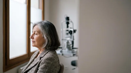Portrait éditorial d'une personne senior française lors d'un examen de la vue, symbolisant la vigilance visuelle après 60 ans